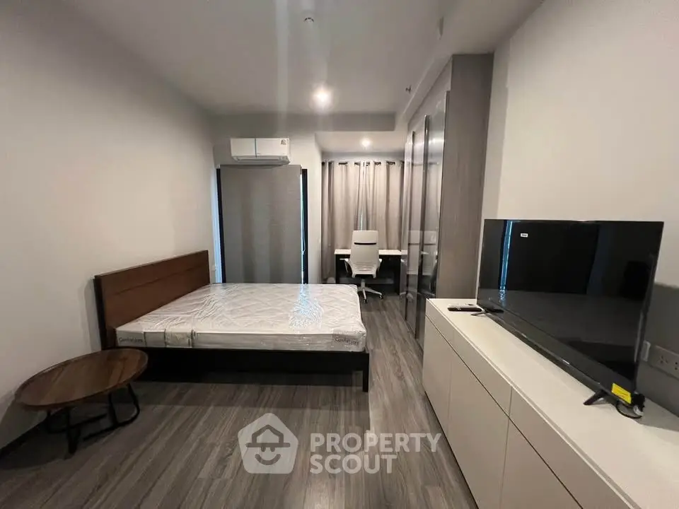Modern bedroom with sleek furniture and TV, perfect for urban living.