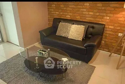 Cozy living room with brick accent wall and modern glass coffee table.
