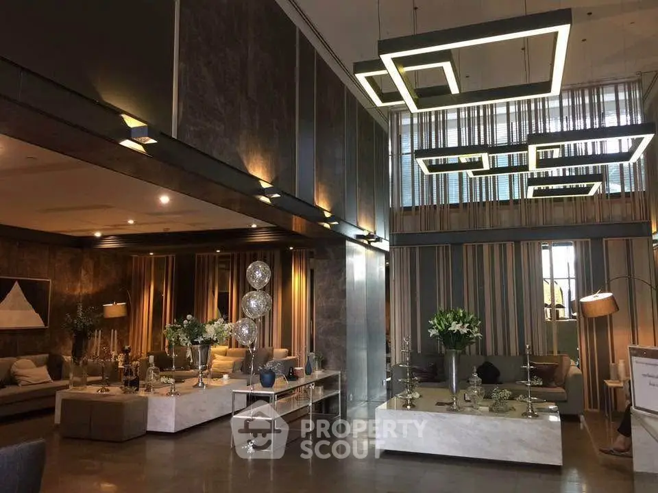 Luxurious modern living room with high ceilings and elegant lighting fixtures.