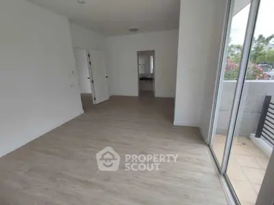 Spacious unfurnished living room with large windows and balcony access