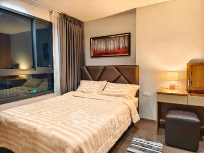 Cozy bedroom with modern decor and large window offering city views