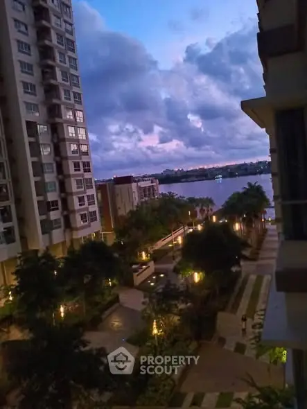 Stunning riverside view from a high-rise apartment at dusk, showcasing serene surroundings and modern architecture.