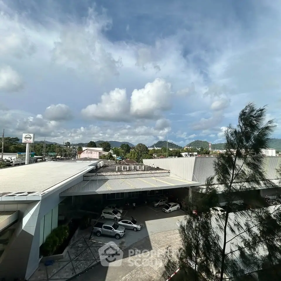 Expansive view of modern building with parking area under a vibrant sky, ideal for commercial use.