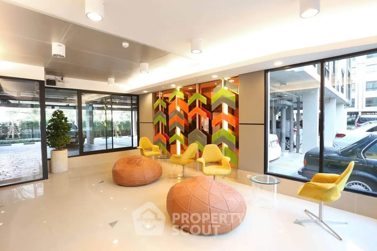 Modern lobby with vibrant decor and comfortable seating in a stylish building.