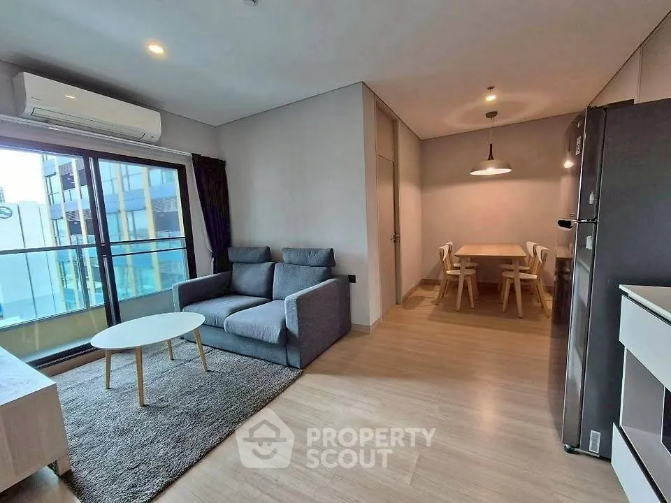 Modern open-plan living room with dining area and large window view.