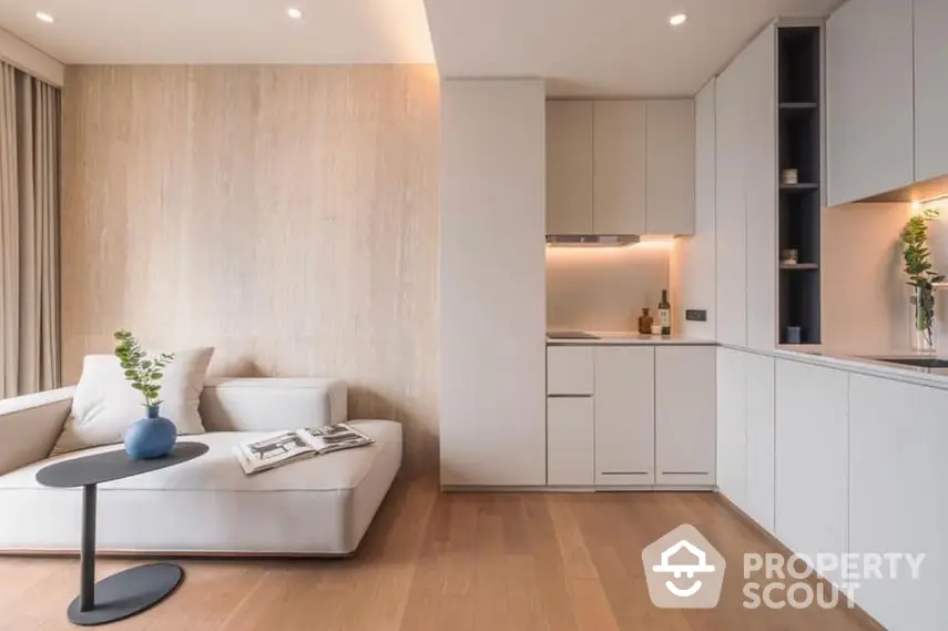 Modern minimalist living room seamlessly connected to a sleek white kitchen with open layout, perfect for entertaining and relaxed living.