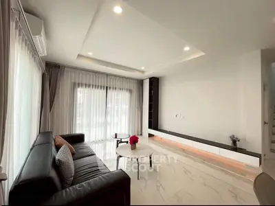 Modern living room with sleek design and large windows for natural light.