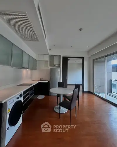 Modern kitchen with sleek design and balcony access in a contemporary apartment.