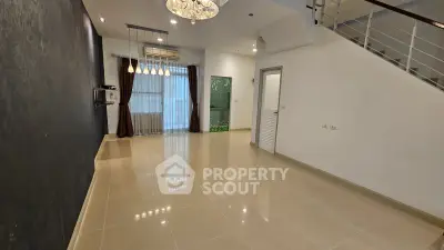 Spacious modern living room with elegant lighting and glossy tiled floors in a contemporary home.