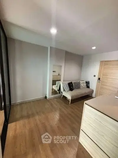 Modern living room with wooden flooring and stylish sofa in a cozy apartment.