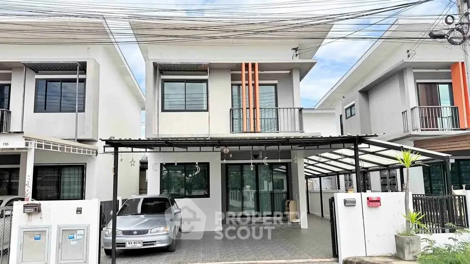 Modern two-story house with carport and sleek exterior design in a suburban neighborhood.