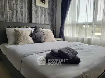 Modern bedroom with stylish decor and large window for natural light.