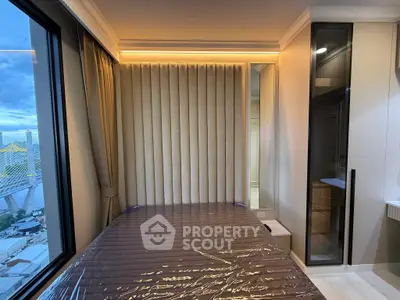 Luxurious bedroom with modern design and large window offering stunning city views.