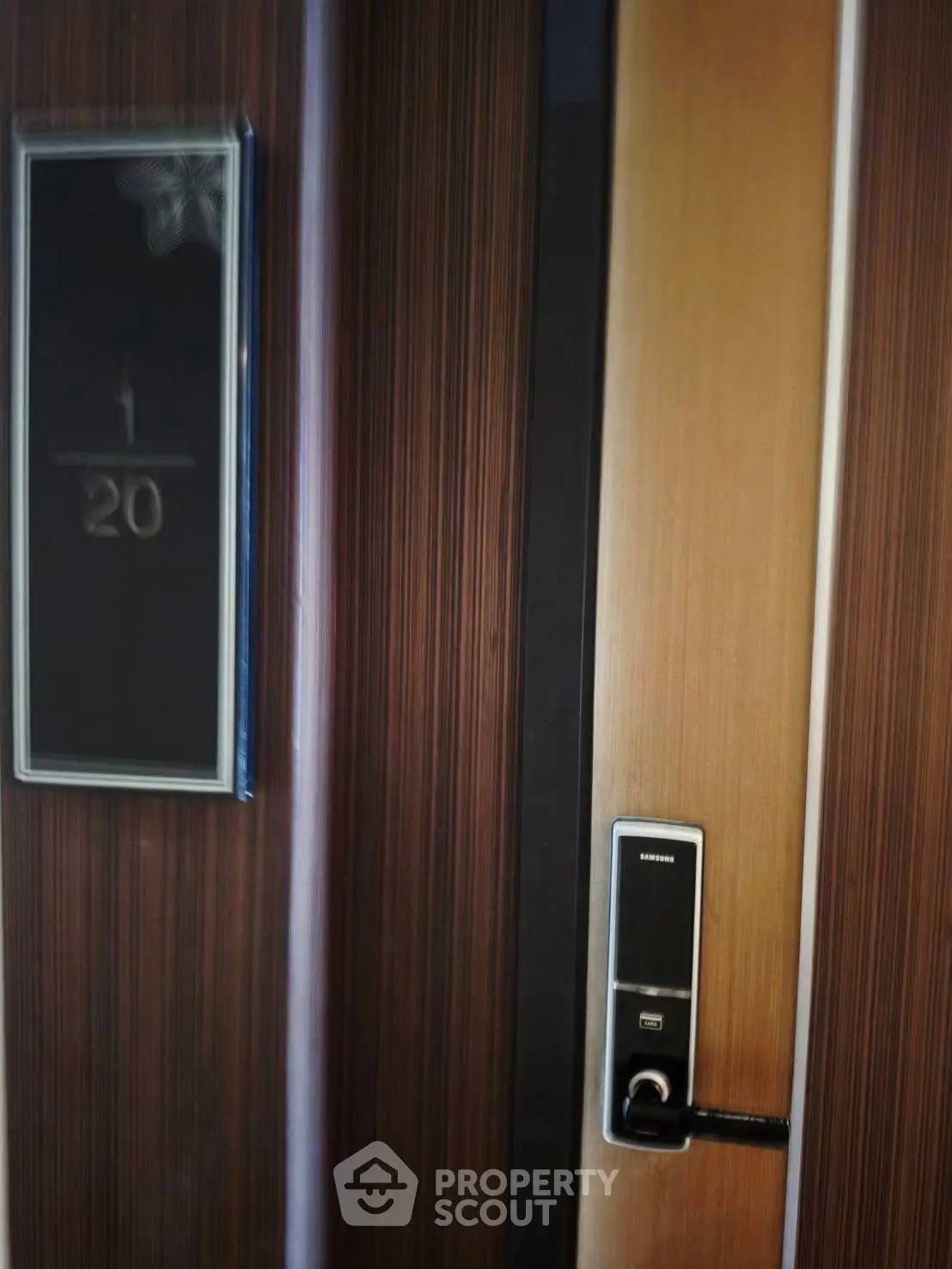 Modern apartment door with electronic lock and room number plaque.
