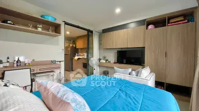 Spacious bedroom with modern wooden cabinetry and ample storage, featuring a cozy bed and integrated entertainment unit, perfect for relaxation.