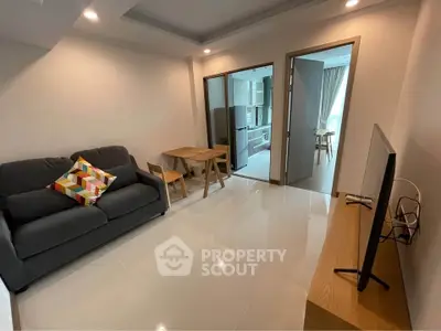 Modern living room with sleek furniture and open kitchen layout, perfect for urban living.
