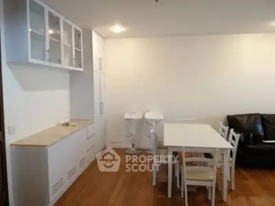 Spacious dining area with modern white furniture and built-in storage cabinets.