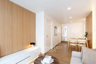 Modern living room with wooden accents and cozy dining area in open layout apartment.
