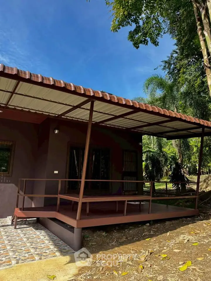 Charming rustic house with a covered porch surrounded by lush greenery, perfect for nature lovers.