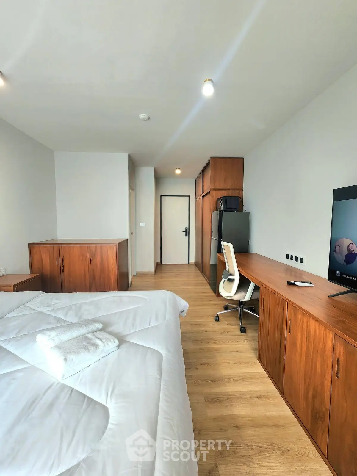 Spacious bedroom with modern wooden furniture and a cozy ambiance