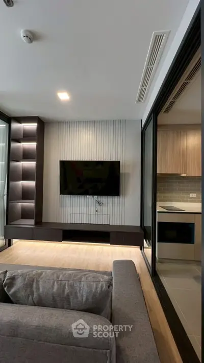 Modern living room with sleek TV setup and open kitchen view