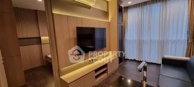 Modern living room with sleek wooden paneling and large TV, featuring ambient lighting and floor-to-ceiling curtains.