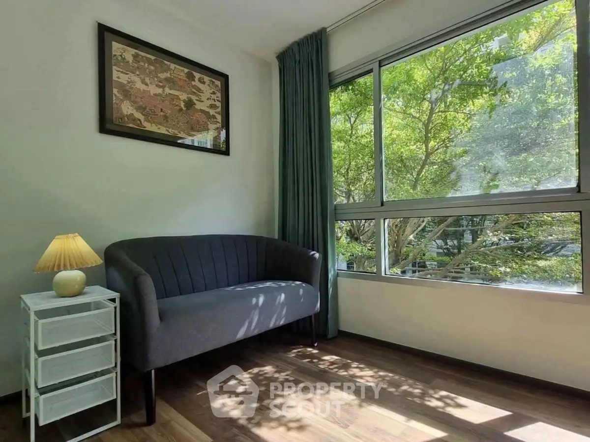 Bright living room with large window and cozy seating area