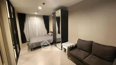 Modern bedroom with cozy sofa and sleek wardrobe in stylish apartment.