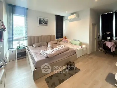 Spacious bedroom with modern decor and large windows for natural light