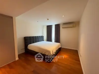 Spacious bedroom with wooden flooring and modern decor