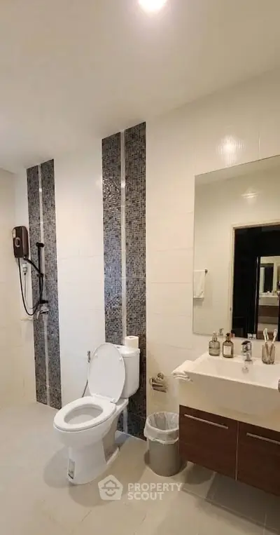 Modern bathroom with sleek fixtures and stylish tile accents, featuring a spacious layout and contemporary design.