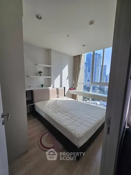 Modern bedroom with city view and natural light in high-rise apartment