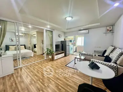 Spacious modern living room with open layout and stylish decor, featuring a cozy seating area and a glimpse of the bedroom.