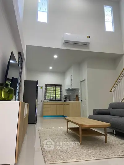 Modern open-plan living room with high ceilings and stylish furniture