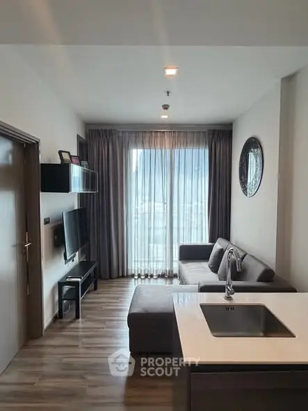 Modern living room with sleek design, featuring a cozy sofa, wall-mounted TV, and large window with city view.
