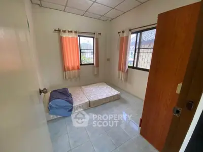 Cozy bedroom with natural light and simple furnishings, ideal for minimalist living.
