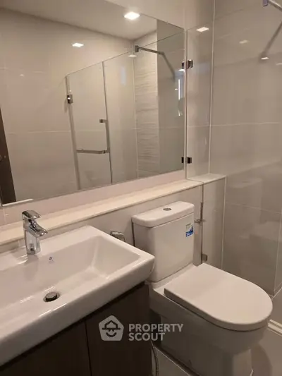 Modern bathroom with sleek fixtures and glass shower enclosure