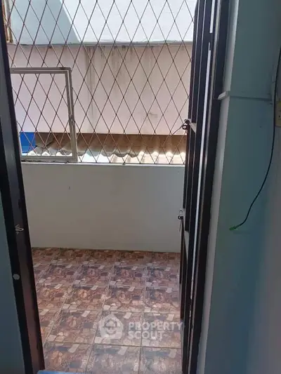 Small balcony with tiled floor and metal railing, perfect for urban living.