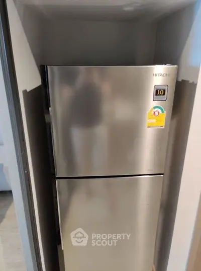 Modern stainless steel refrigerator in a sleek kitchen alcove.