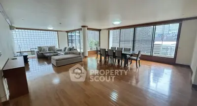 Spacious living room with hardwood floors and large windows in modern apartment.