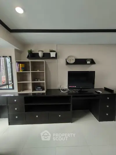 Modern study room with sleek black furniture and wall-mounted shelves