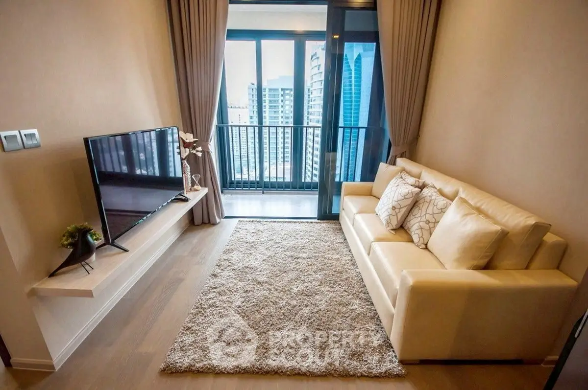 Modern living room with city view, cozy sofa, and sleek TV setup.