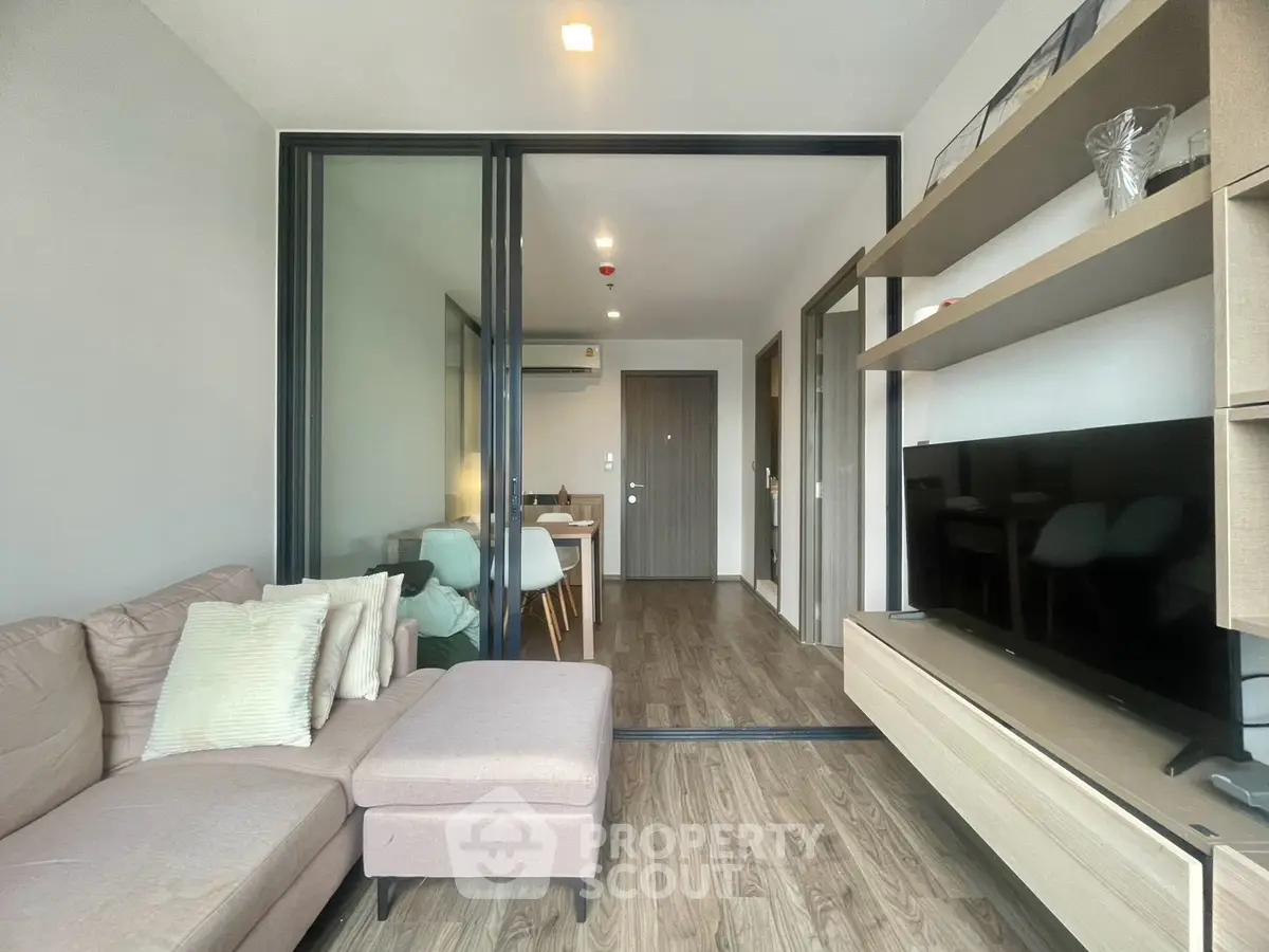 Modern living room with stylish decor and open layout, featuring a cozy sofa and sleek TV unit.
