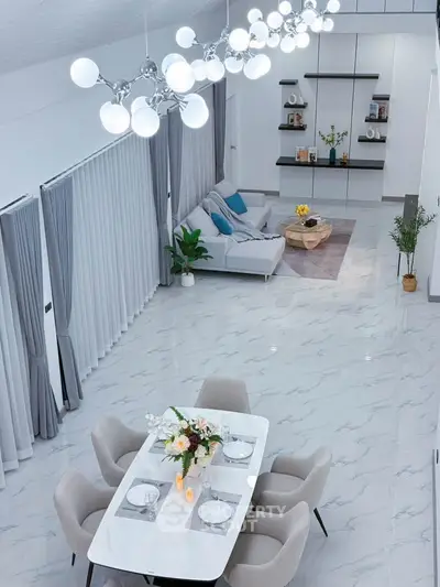 Luxurious open-plan living and dining area with modern decor and elegant lighting.