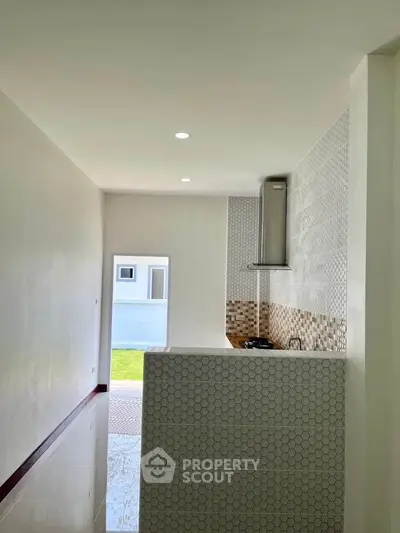 Modern kitchen with open layout and stylish backsplash in a bright home.