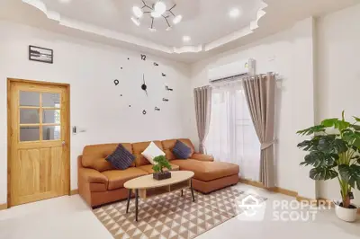 Spacious and well-lit living room with elegant brown sofa set, modern wall clock decor, and vibrant indoor plant adding a touch of greenery.