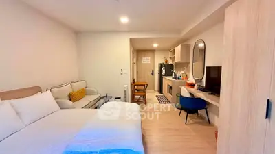 Modern studio apartment with cozy living area and compact kitchen, ideal for urban living.