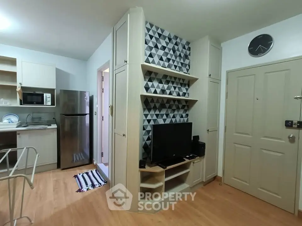 Modern apartment interior with stylish kitchen and living area featuring geometric wall design.