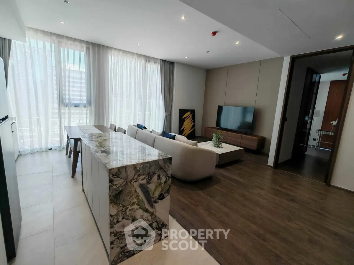 Luxurious modern living room with elegant marble island and large windows.