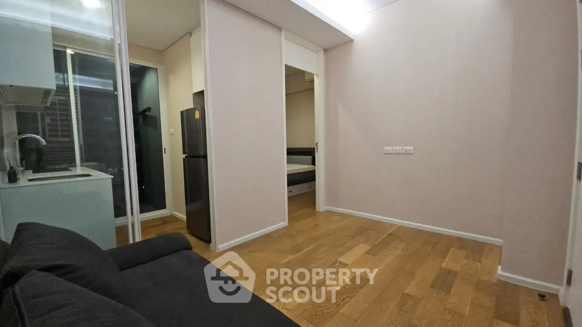 Modern apartment interior with open layout, featuring a cozy living area and sleek kitchen with stainless steel appliances.